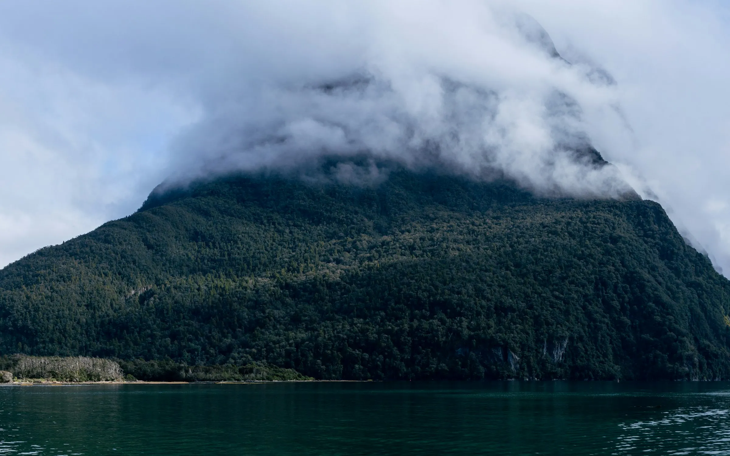 Mountains reflected in the still water of Milford Sound